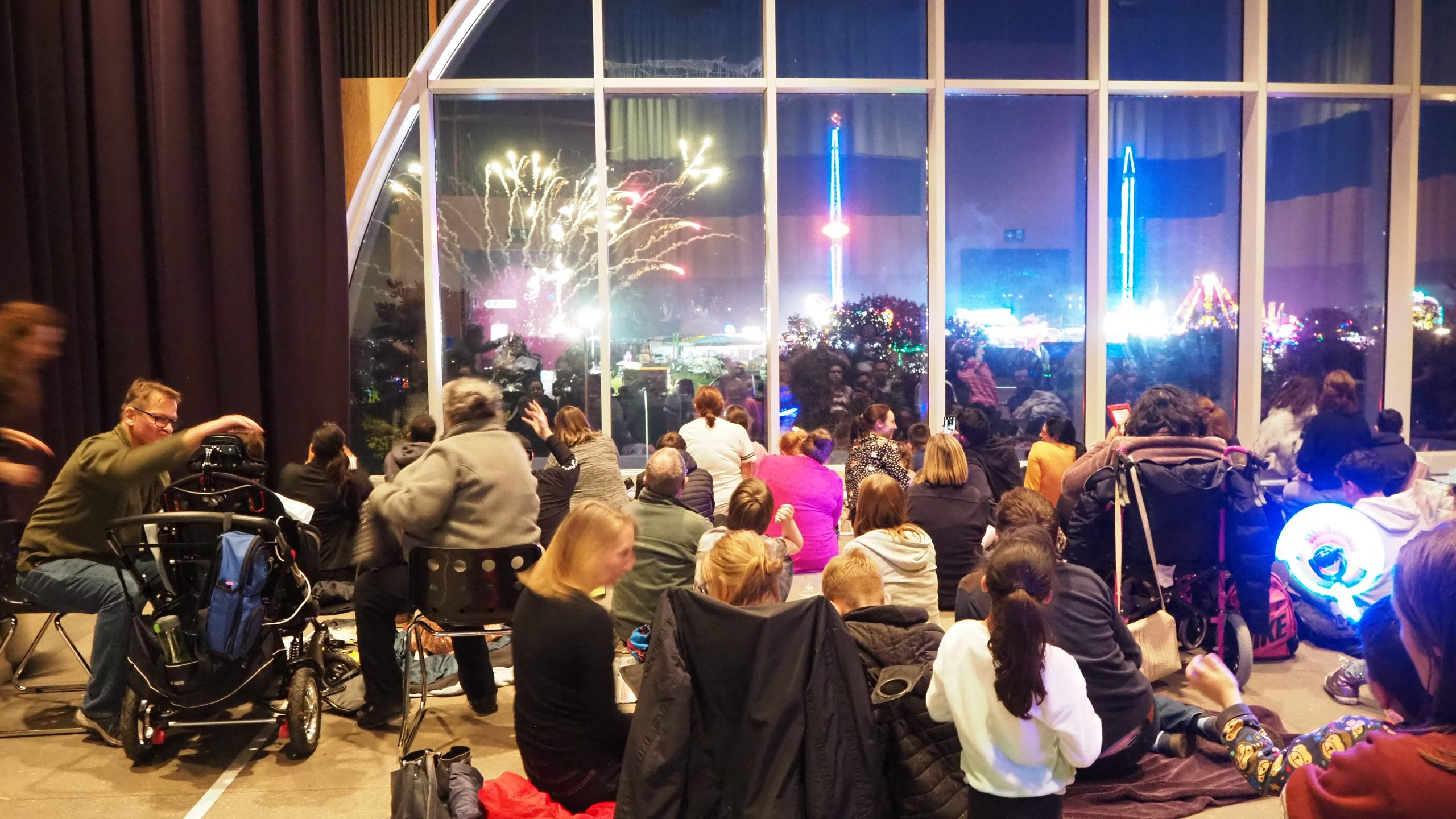 Families in the Sky Room watching out the window at the fireworks display